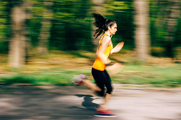 istock Young woman running outdoors in the park 472215134