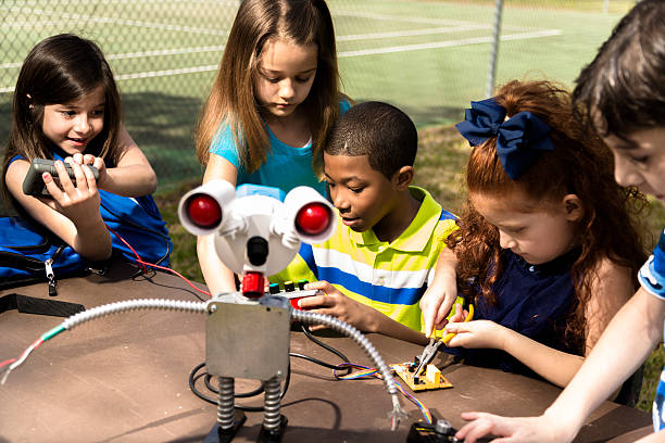 little engenheiros! crianças da escola primária colaborar em'robot'que criou. - smiling little girls little boys autumn imagens e fotografias de stock