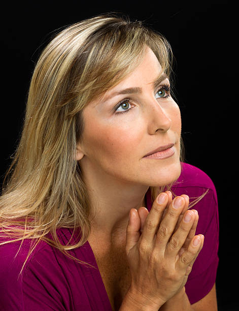 istock Mature woman praying 472216231
