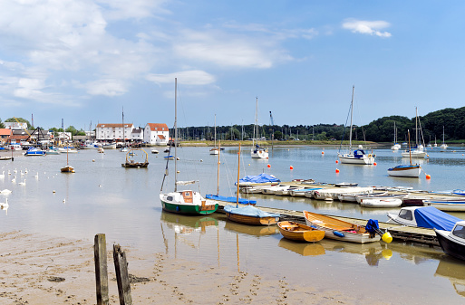 An assortment of boats at low tide on the River Deben at Woodbridge in Suffolk, Eastern England. Woodbridge is a picturesque town popular with the sailing fraternity and tourists.