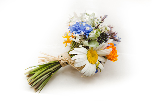 A beautiful bunch of wild flowers making up a wedding bouquet on a white background.