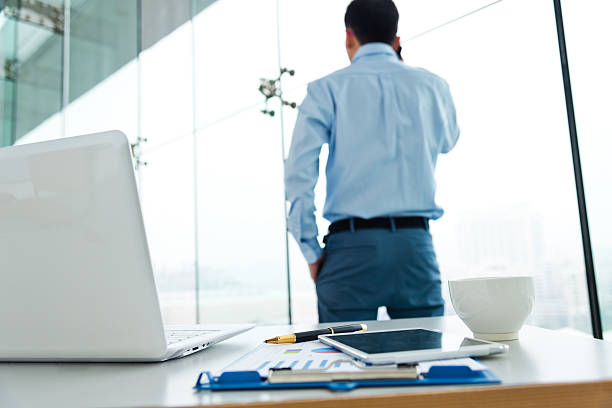 istock A man backing away from his desk talking on the phone 472219205