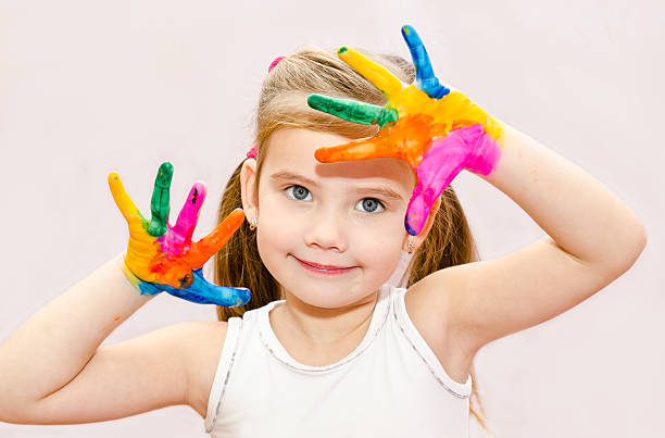 istock Cute smiling little girl with hands in paint 472220329
