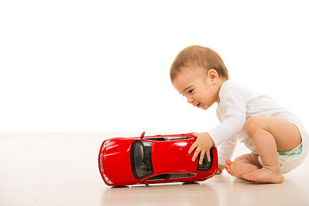 istock Toddler boy playing with big car 472220389