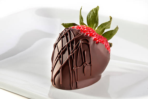 Chocolate Strawberry Strawberry dipped in dark chocolate on a white plate with chocolate drizzle. chocolate covered strawberries stock pictures, royalty-free photos & images
