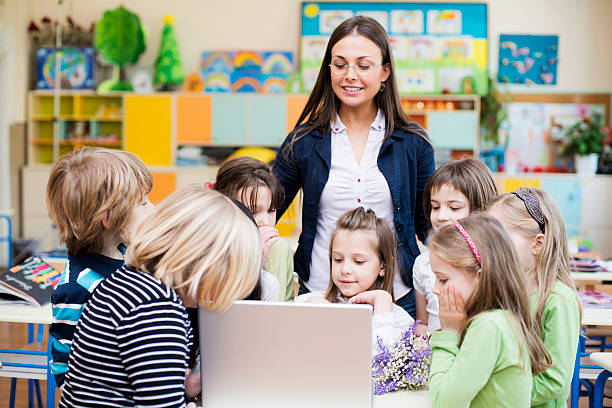 istock Teacher and children with computer at school 472223233