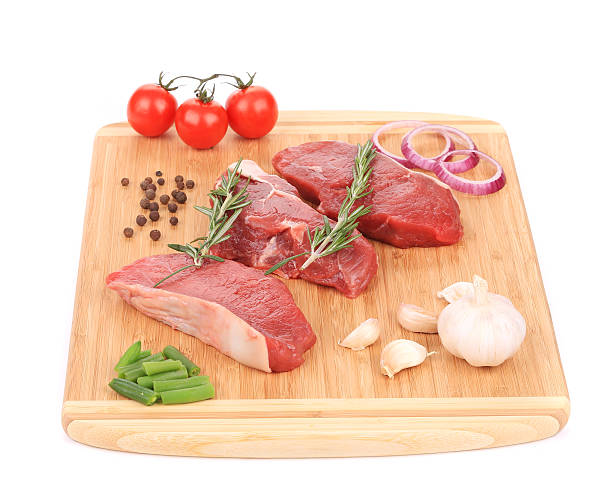 istock Raw beef steaks on a wooden cutting board. 472223363
