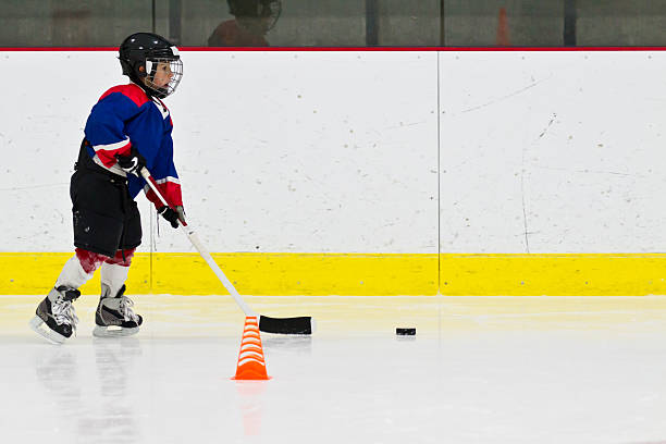 Child playing ice hockey practicing in full kit stock photo