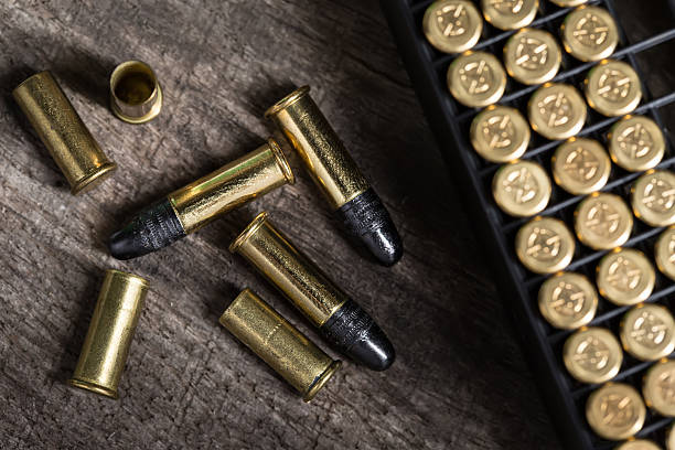 Scattering of small caliber cartridges on a wooden background stock photo