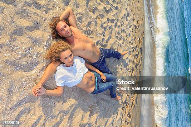 Jovem Casal Na Praia - Fotografias de stock e mais imagens de Abraçar - Abraçar, Adulto, Amizade