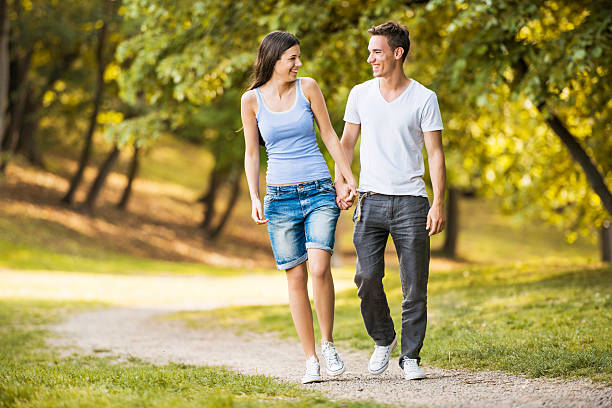 Beautiful sunny meadow in the heat of summer. Romantic date. young coupe walking through the grasses and flowers and flirting together