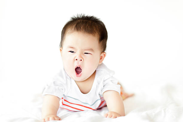 jolie fille bébé ramper sur fond blanc lit - baby yawning asian ethnicity newborn photos et images de collection