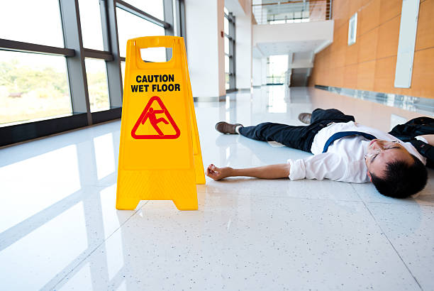 A yellow caution sign is on the floor. The sign warns people that the floor is wet