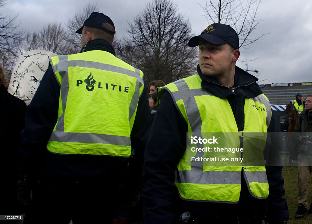 Riot Police The Hague, Holland - January 21, 2011: Riot police watch the crowd during a demonstration against member of parliament Wilders, seen on a cartoon placard on January 21, 2011 in The Hague, Holland Adult Stock Photo