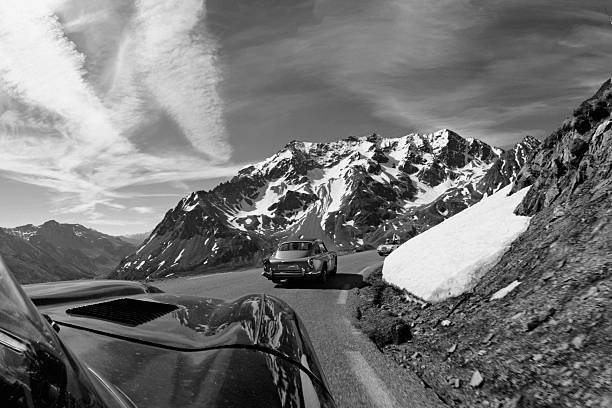 Old timer cars  on a background of the Alpine ridge . To simulate the effect it films , grain and texture was added intentionally .