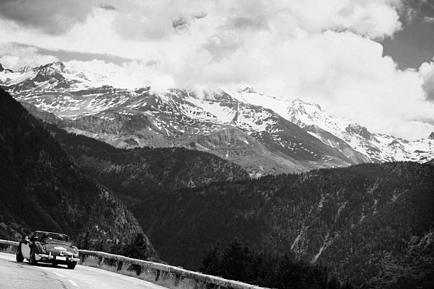Old timer car  on a background of the Alpine ridge . To simulate the effect it films , grain and texture was added intentionally .