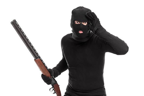 istock Burglar in black with rifle looking through an imaginary glass 472232884
