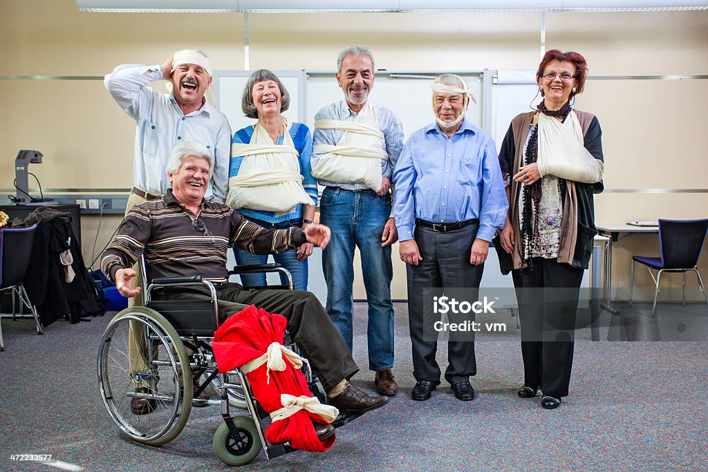 Alegre grupo de feridos idosos depois de primeiros socorros de treino - Foto de stock de Perna Quebrada royalty-free