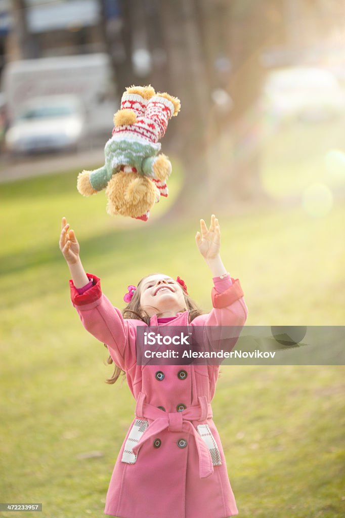 Little Girl Playing with her Teddy Bear  Outdoors Little Girl Playing with her home-made Teddy Bear in the Bright Spring Day  Catching Stock Photo