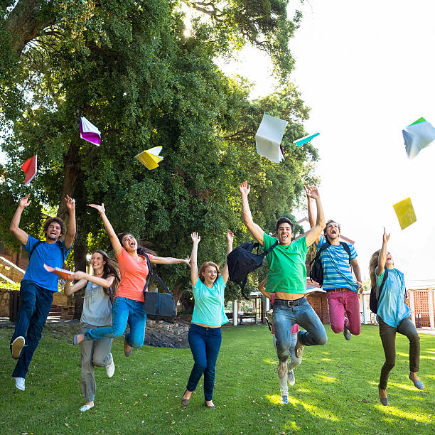 istock Excited students leaping and throwing their books 472234703