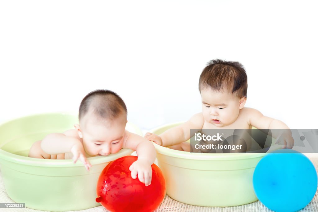 baby girl and boy twins having a bath East asian baby girl and boy twins having a bath with balls Asian and Indian Ethnicities Stock Photo