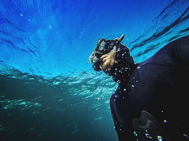 Free diver descending in the abyss