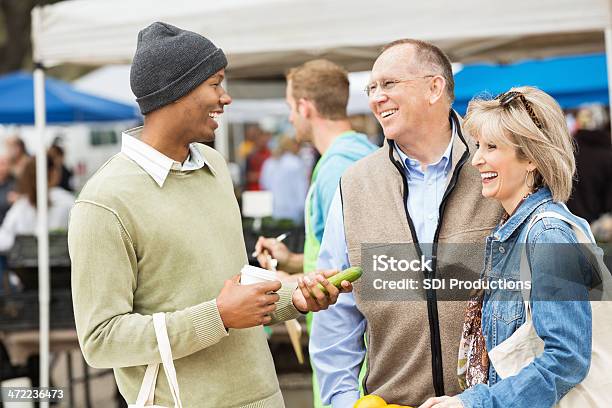 Friends Meeting At The Local Farmers Market Stock Photo - Download Image Now - Agricultural Fair, Healthy Lifestyle, Senior Adult