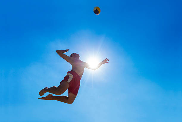 vista lateral de jugador de vóleibol sirve la pelota - volleyball volleying human hand men fotografías e imágenes de stock