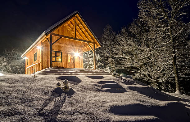 istock Rustic cabin in winter blizzard snowstorm at night 472237479