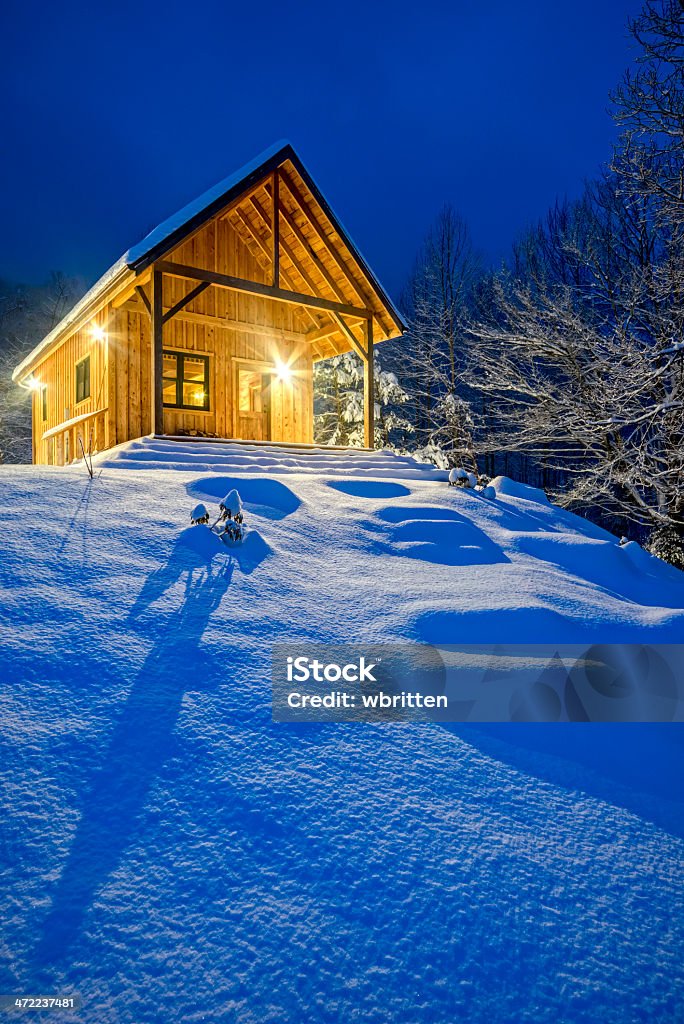 Rustico chalet in inverno bufera di neve molto forte alla sera - Foto stock royalty-free di Capanna di legno