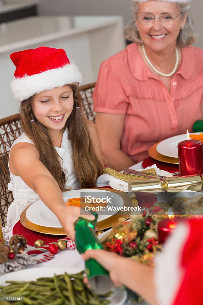 Geschwister ziehen Christmas Cracker mit Esstisch - Lizenzfrei Cracker Stock-Foto