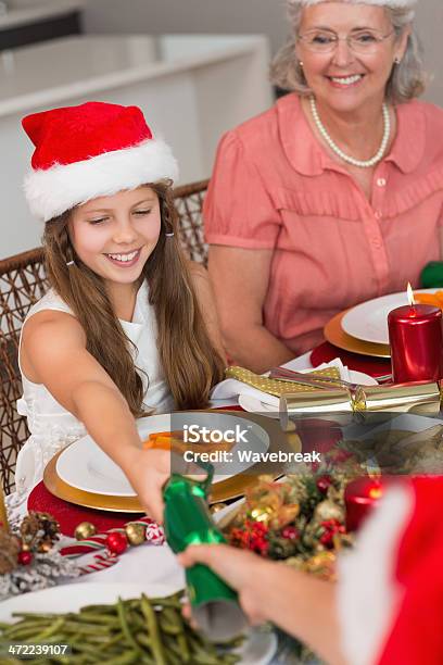 Geschwister Ziehen Christmas Cracker Mit Esstisch Stockfoto und mehr Bilder von Cracker - Cracker, Weihnachten, 12-13 Jahre