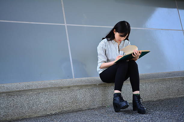 istock Long hair girl sat down to read book 472239906