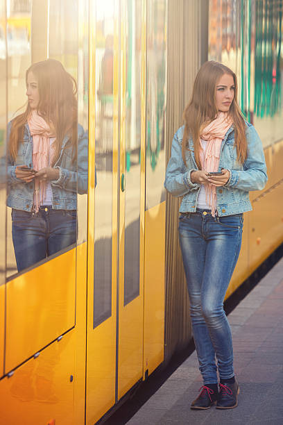 istock young woman in the tram stop 472240085