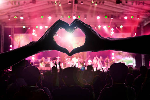 crowd of people at during a concert crowd of people at during a concert with a heart shaped hand shadow male and female animal internal organ photos stock pictures, royalty-free photos & images