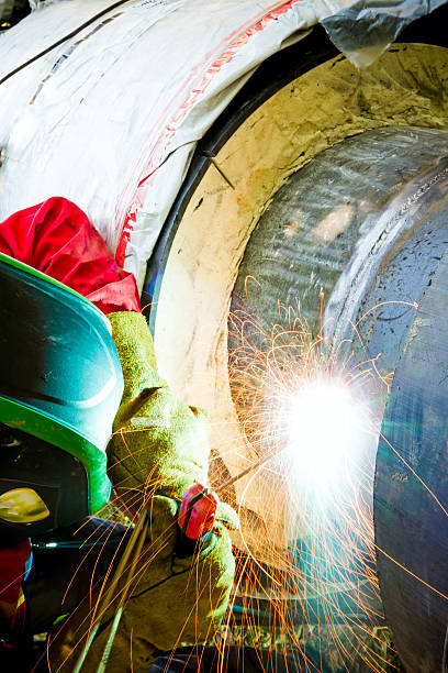 istock Close up shot welder until welding, sparks flying around. 472240272