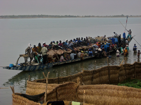 Segou,Mali-February 16,2009: Boat overloaded with dozens of passengers on the way back from weekly Segou market.