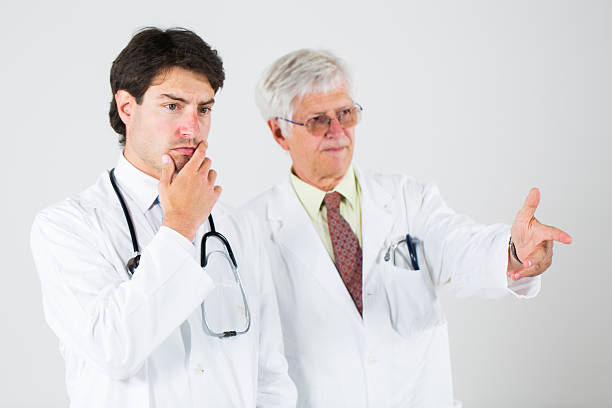 istock Young and senior doctor discussing about problems 472240993