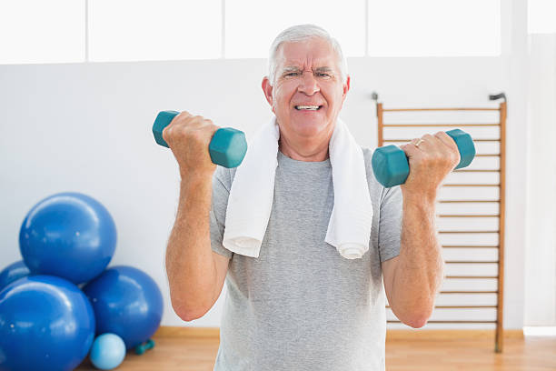 istock Senior man picking up dumbbells 472242323