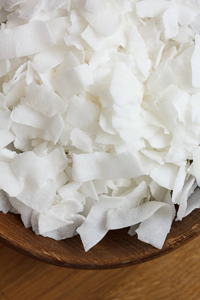 istock Dark bowl of shaved coconut on wood table. 472243114