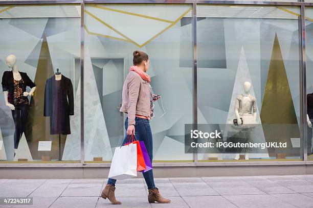 Young Woman With Shopping Bags Looking At Window Display Stock Photo - Download Image Now