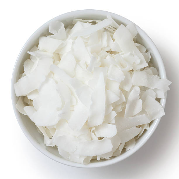 Coconut flakes in white ceramic bowl. From above.