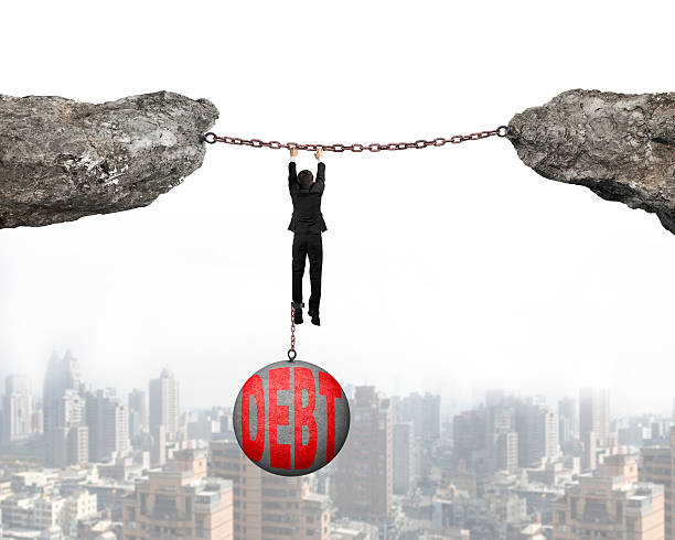 istock Businessman shackled by debt ball hanging on chains connected cl 472249574