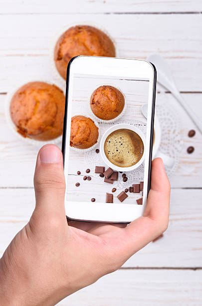 mani prendendo foto tazza di caffè con muffin con uno smartphone. - coffee muffin pastry blueberry muffin foto e immagini stock