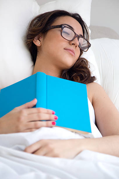 istock Beautiful young woman sleeping after read a book. 472254752