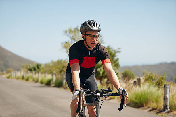 istock Young man riding bicycle on open road 472258040