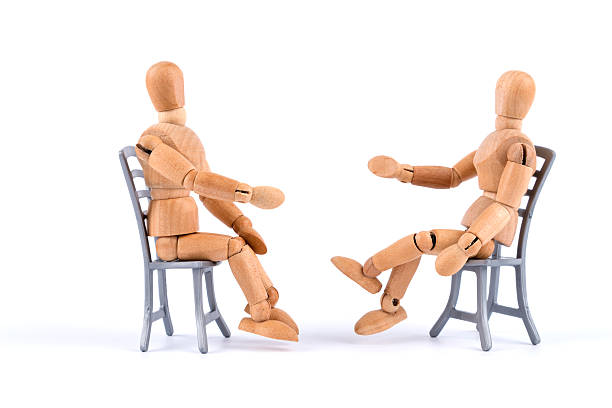 mannequin en bois parler ensemble sur des chaises-médiation - explantation photos et images de collection
