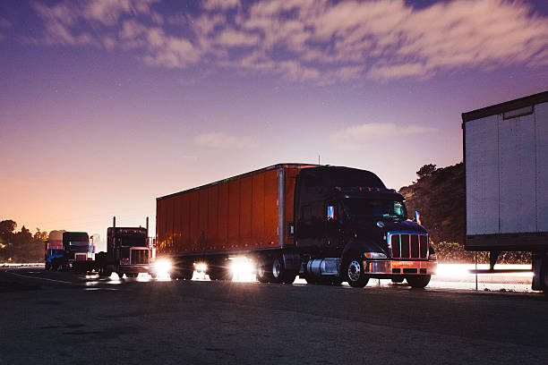 A line of big rig trucks during sun rise stock photo