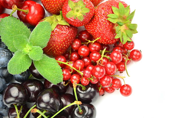 Fresh berries: raspberries, gooseberries, currants, red currant on an oak cutting board. Flat lay, top view.