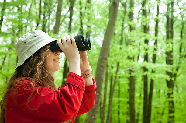 istock Girl watching nature with binoculars 472287382